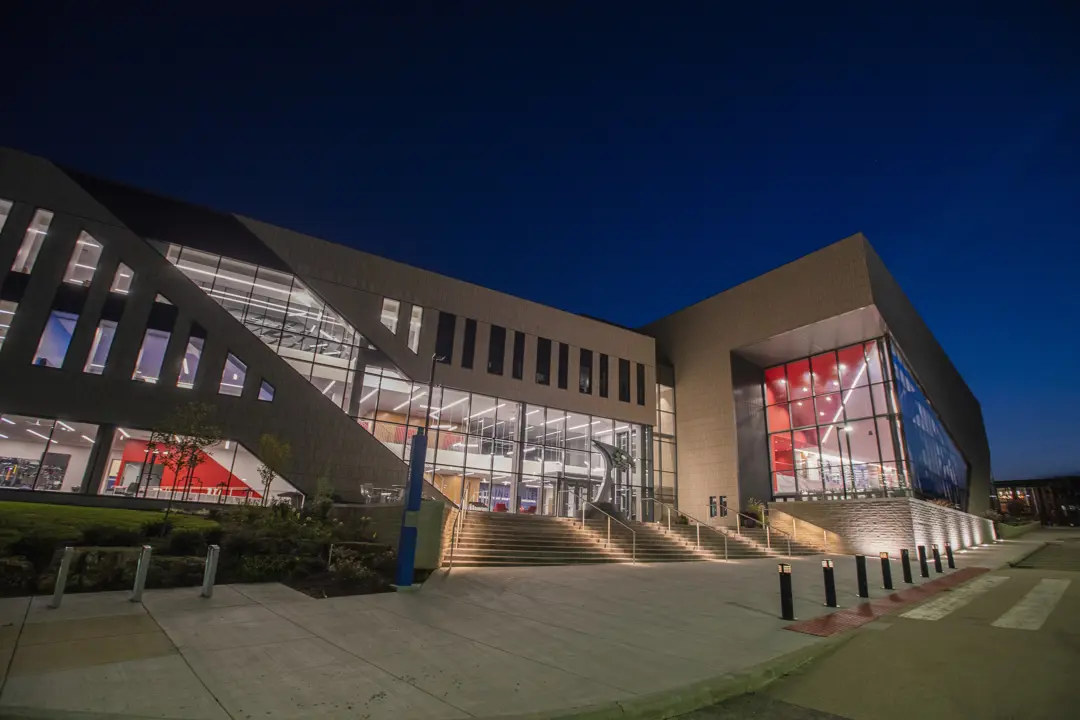 Exterior view of the Screaming Eagles Athletic Complex, home of the Kinesiology and Sport department, at night