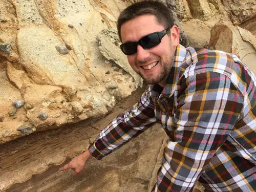 Geology graduate Michael Stephens  pointing out cross-bedding in a sandstone exposed along the California coast