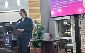 Student giving speech during Lamda Nu Honor Society Induction