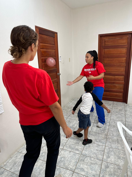 OT students playing ball with a child at the clinic