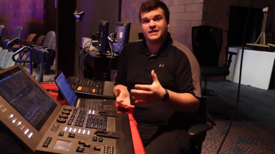 USI performing arts graduate Blake Whitehouse sits in front of the sound board in the USI Performing Arts Center