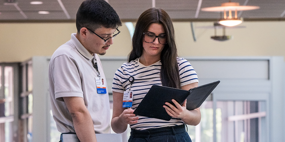 Photo of two health informatics interns looking at a tablet