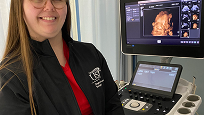 Photo of Sarah McSparin in front of sonography machine