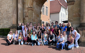 Large group of students on Germany trip in front of an archway