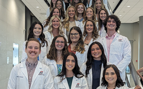 OT students in white coats on steps