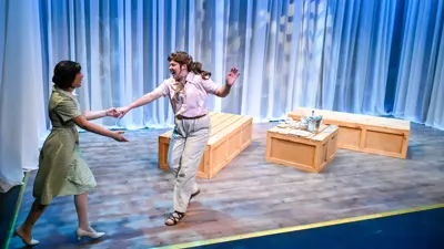 Two actors performing on a lighted, minimal set