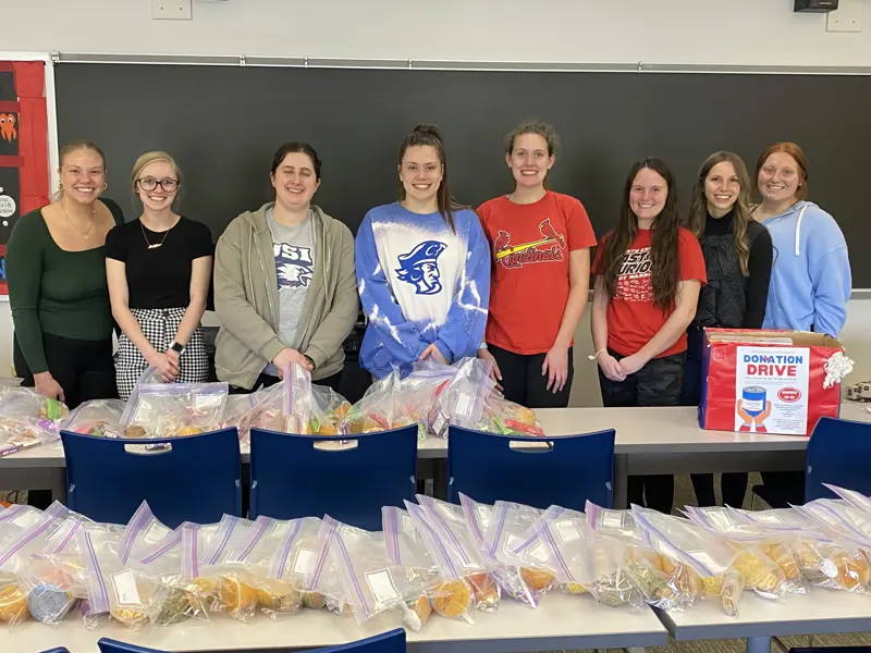 Students with assembled food bags to donate