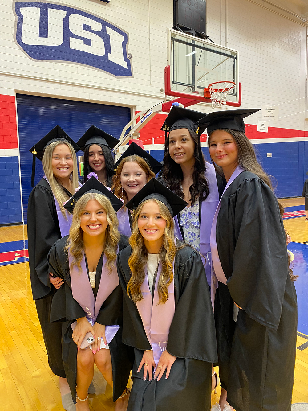 Dental assisting students at graduation wearing caps and gowns