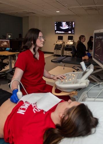 Student using sonography machine in lab
