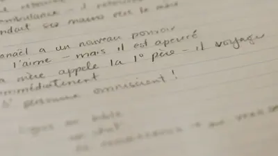 French words written in pencil on a spiral bound notebook
