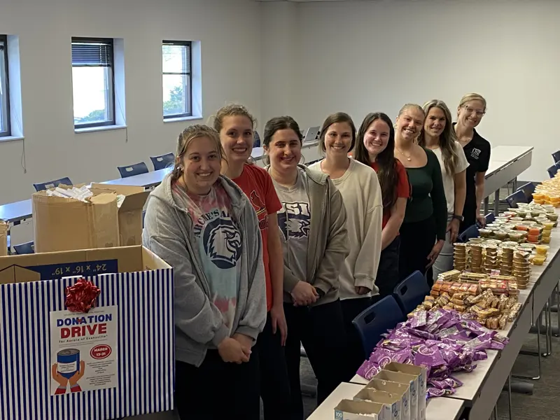 Students standing next to the food donation box