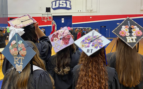Respiratory therapy students wearing decorated caps at graduation