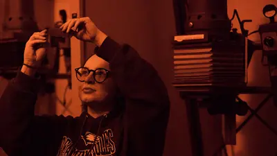 Student holds up a film in the photography dark room
