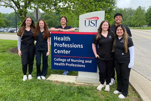 RT Grad Photo in front of Health Professions Center sign