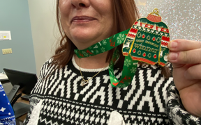 Ugly sweater contest winner holding her medal