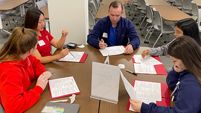 Students discussing case study at a table during AHEC event