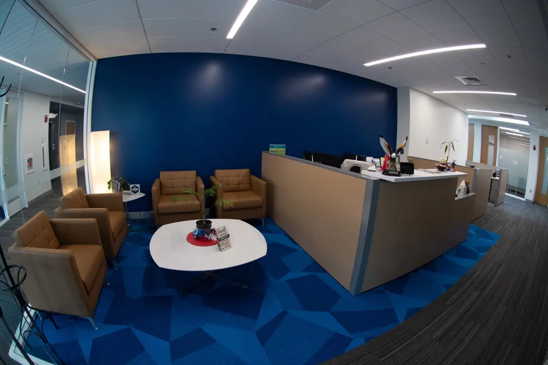 Interior view of the Kinesiology and Sport Department office with a seating area and a reception desk