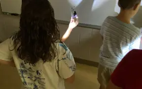 SCA Students experiment with light and shadow during an interactive science lesson.