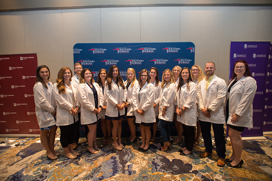 Group of USI students with white coats at Stone Center opening