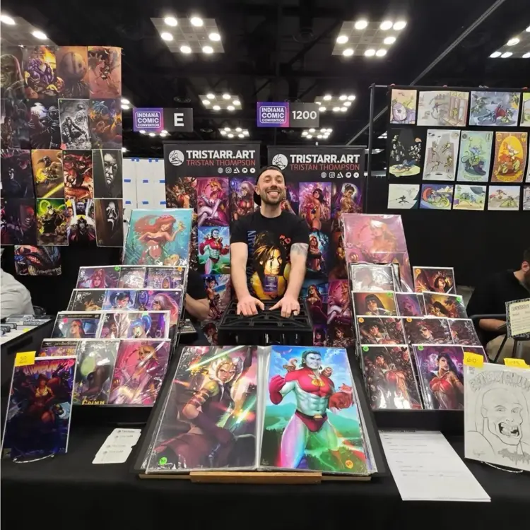 Artist surrounded by artwork in a sales booth