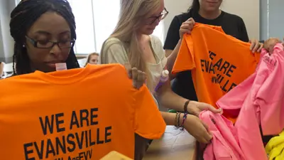 Public relations students fold "We Are Evansville" t-shirts for a service learning project