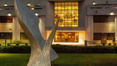 Exterior view of the Orr Center and public art piece at night