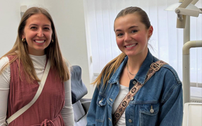 Students smiling for photo inside dental office