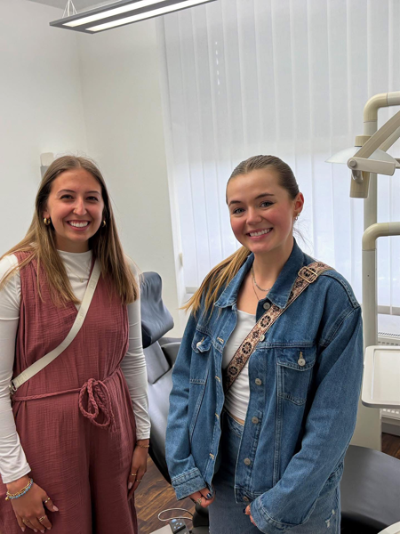 Students smiling for photo inside dental office