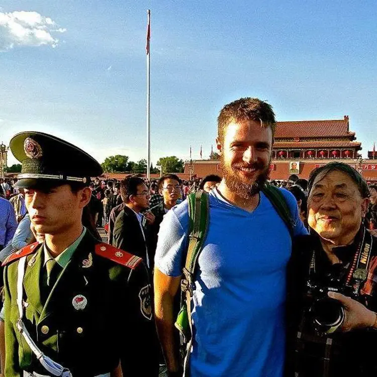 USI history graduate Kris Pickett poses with men wearing Chinese military uniforms