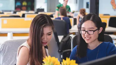 Two people work on the computer.