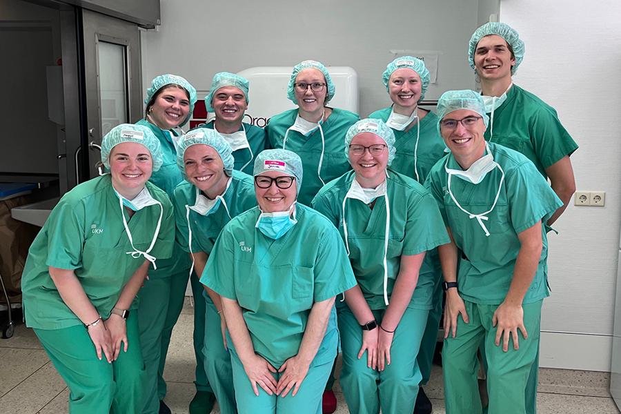 Students wearing green scrubs at German health facility