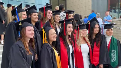Group of students pose in their commencement regalia