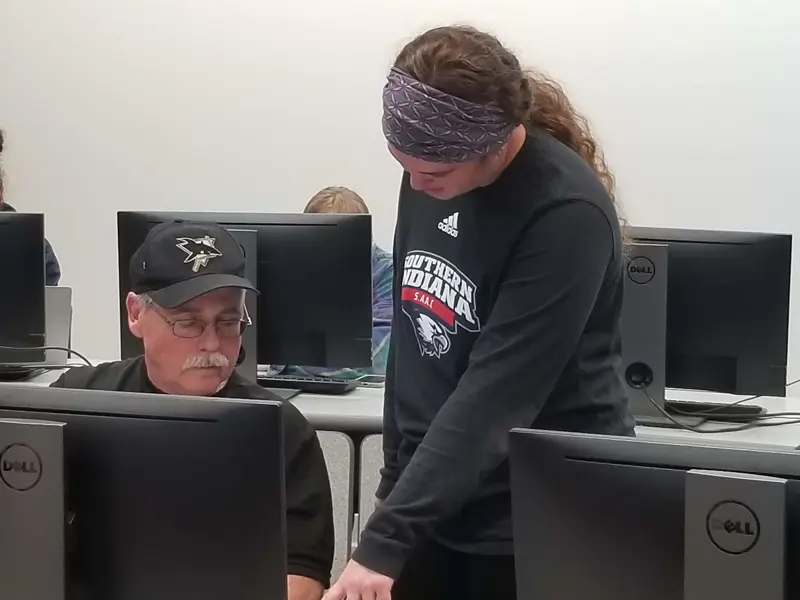 Two USI students work together in a computer lab classroom
