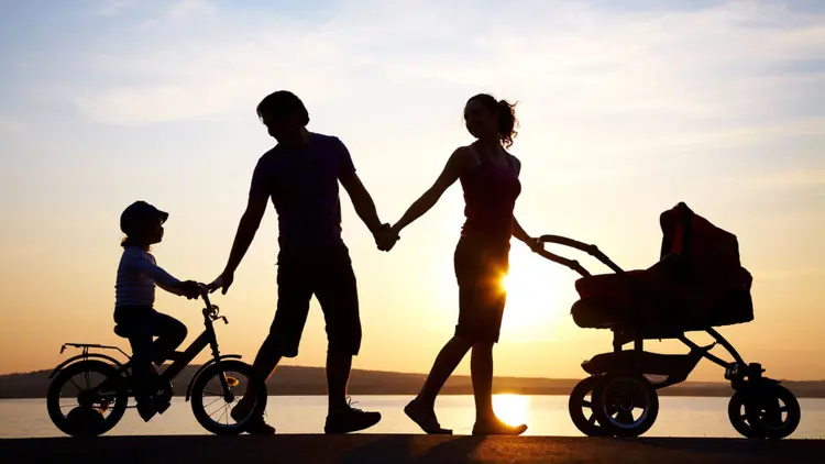 Silhouette of a family taking a walk at sunset