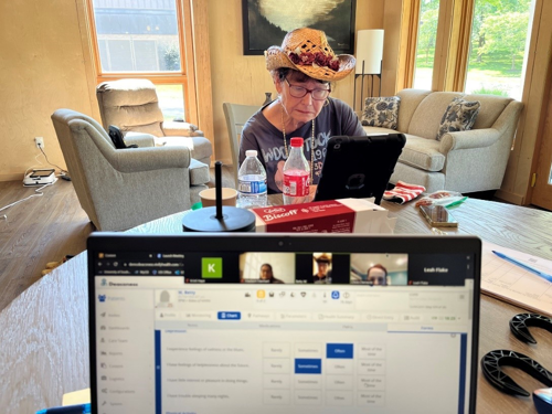 Standardized patient Betty sits across the table using a tablet