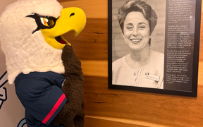 Archie by a framed photo of food pantry founder, Sandra Lawrence