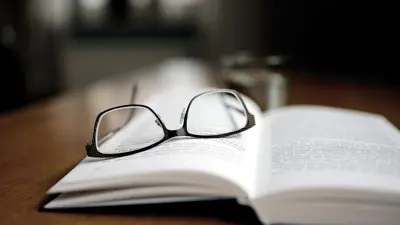 A pair of glasses sitting on a textbook.