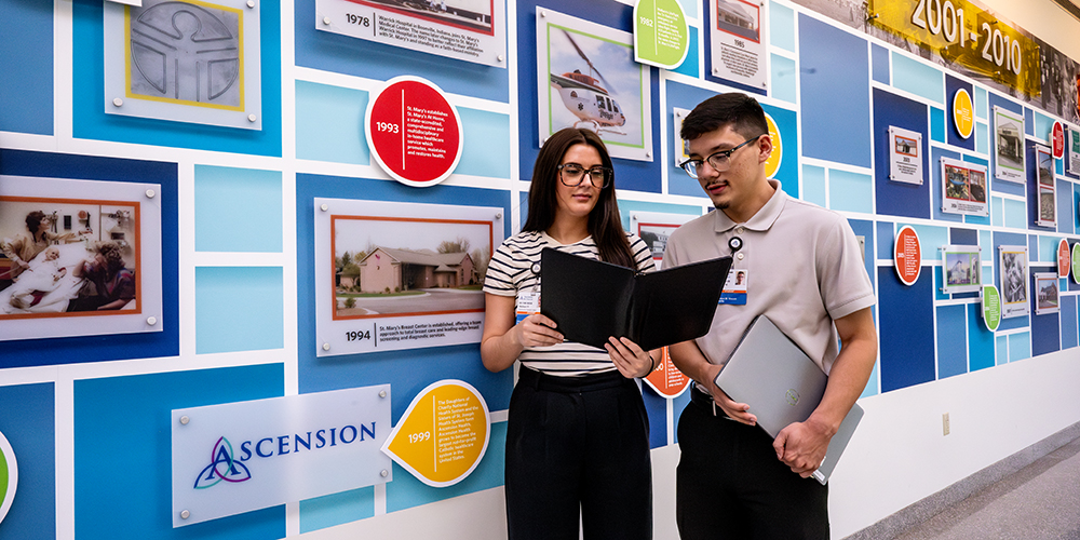Two students at a local hospital looking at a tablet
