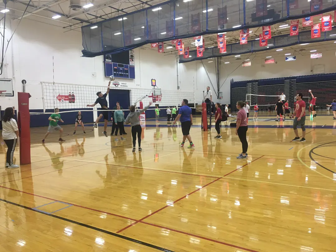 Students playing volleyball on the Recreation, Fitness and Wellness Center indoor court