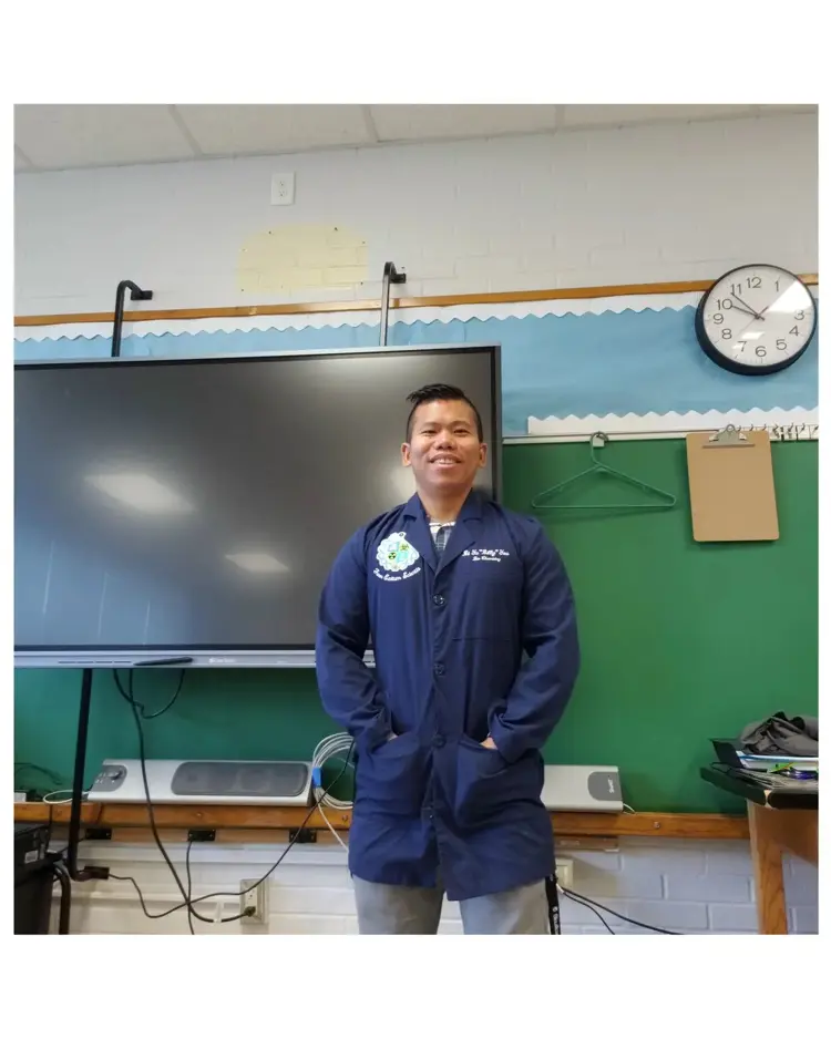 Casual portrait of USI science teaching graduate Bi Yu You in his classroom