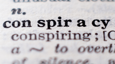 Up close view of the word "conspiracy" in a dictionary entry