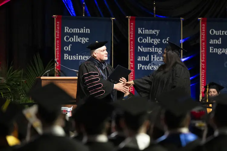 President Bridges shaking a student's hand at graduation