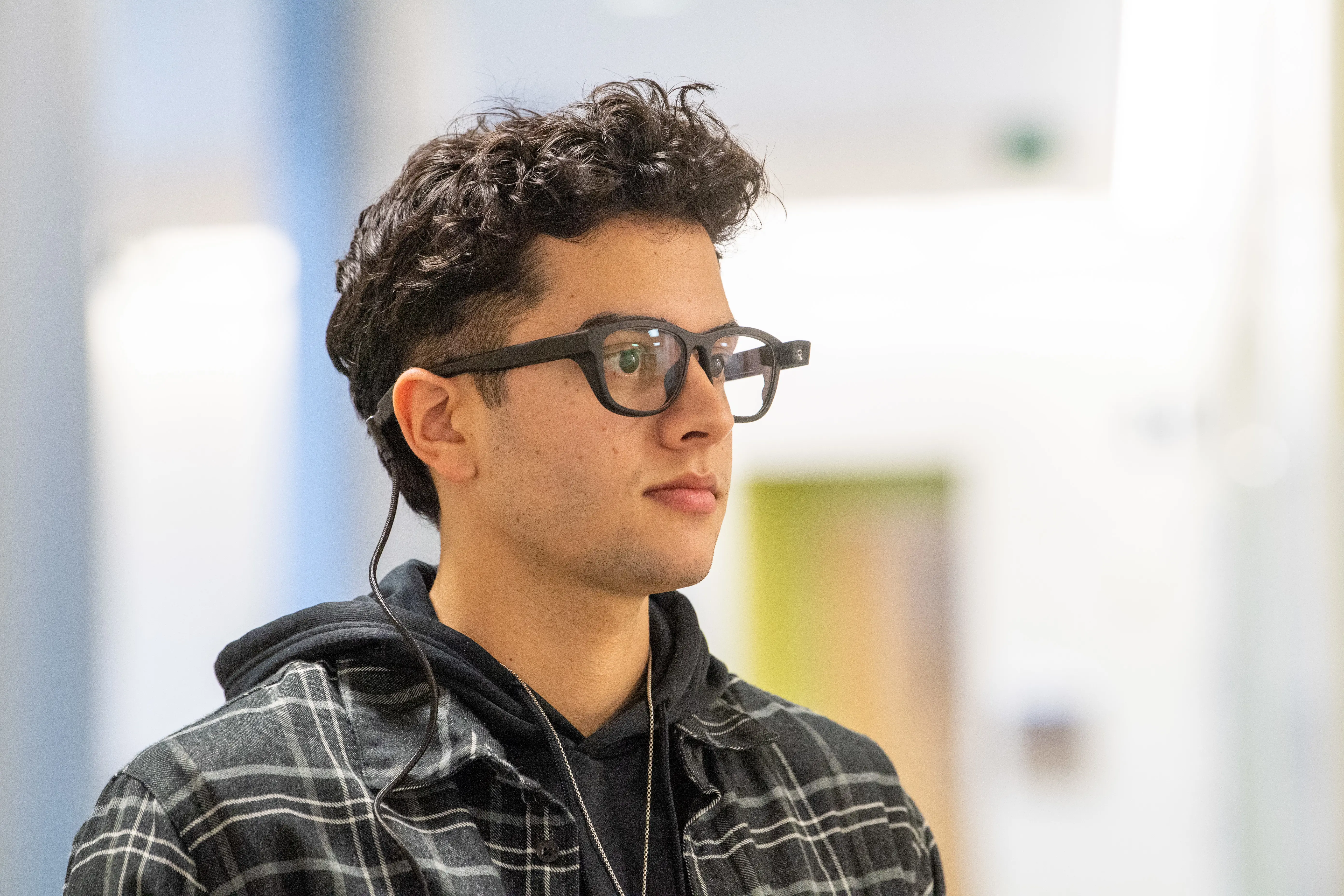 A man with eye-tracking glasses looks toward the side.