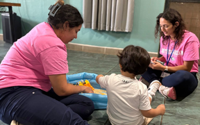 OT students sitting on the floor with a child
