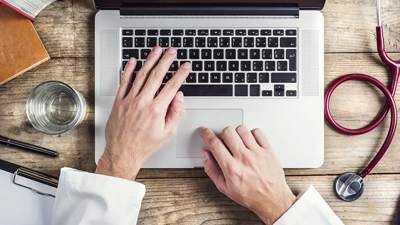 A first-person perspective view of hands on a laptop keyboard
