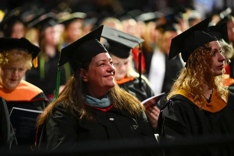 Photo of USI faculty member in regalia smiling during commencement ceremony