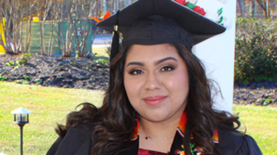 Casual portrait of USI health administration graduate Laisha Gonzalez Ramos in her cap and gown