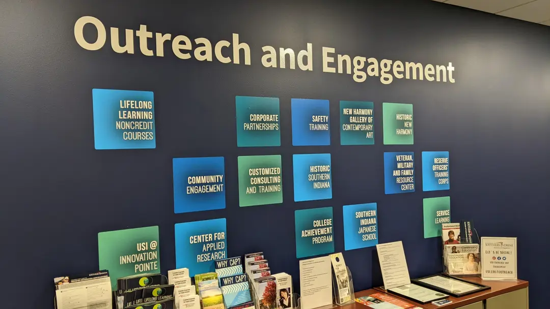 Wall painted with "Outreach and Engagement" and tiles for each of the different programs offered