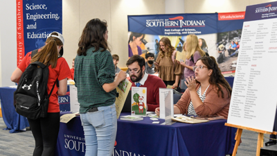 Students talking to advising table on campus