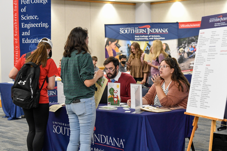 Students talking to advising table on campus